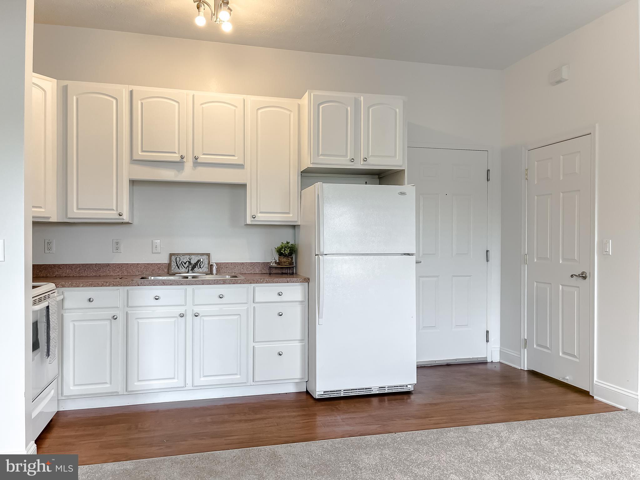 48673 Trapp Road St. Inigoes, MD 20684 - Photo 10 of 39 a kitchen with granite countertop white cabinets and refrigerator
