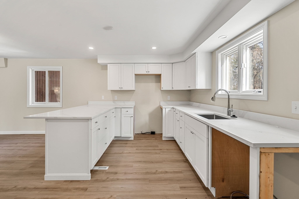 153 Coffin Road, Unit 10 Epping, NH 03042 - Photo 21 of 31 a large white kitchen with stainless steel appliances sink and window
