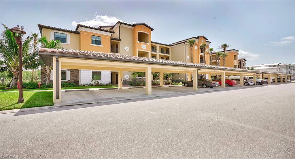 9584 Trevi Court, Unit 5227 Naples, FL 34113 - Photo 1 of 26 a front view of building with small yard and palm trees