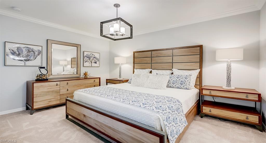 9584 Trevi Court, Unit 5227 Naples, FL 34113 - Photo 12 of 26 a bedroom with a bed and a chandelier