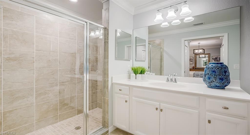 9584 Trevi Court, Unit 5227 Naples, FL 34113 - Photo 14 of 26 a bathroom with a granite countertop sink a mirror and a shower