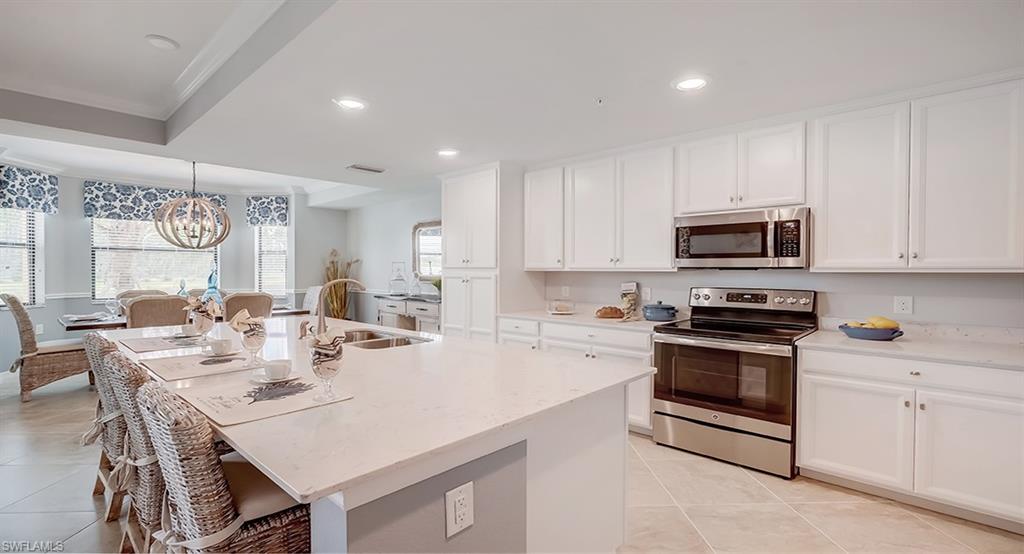 9584 Trevi Court, Unit 5227 Naples, FL 34113 - Photo 9 of 26 a kitchen with a stove a sink and cabinets