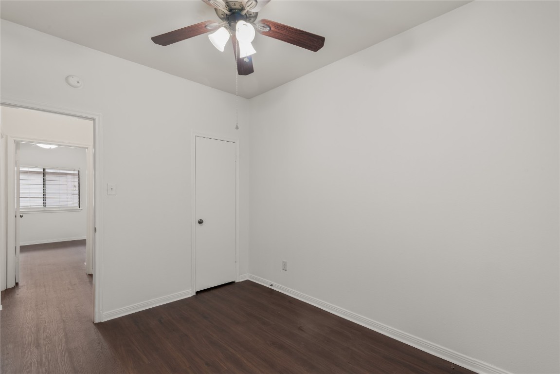 3500 Tangle Brush Drive, Unit 193 Spring, TX 77381 - Photo 15 of 26 Bedrooms have a ceiling fan, and dark wood flooring. There is a door leading to another room and a doorway with a view of a window, offering natural light to the space.