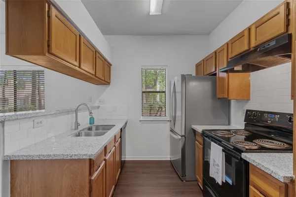 a kitchen with stainless steel appliances granite countertop a refrigerator and a stove