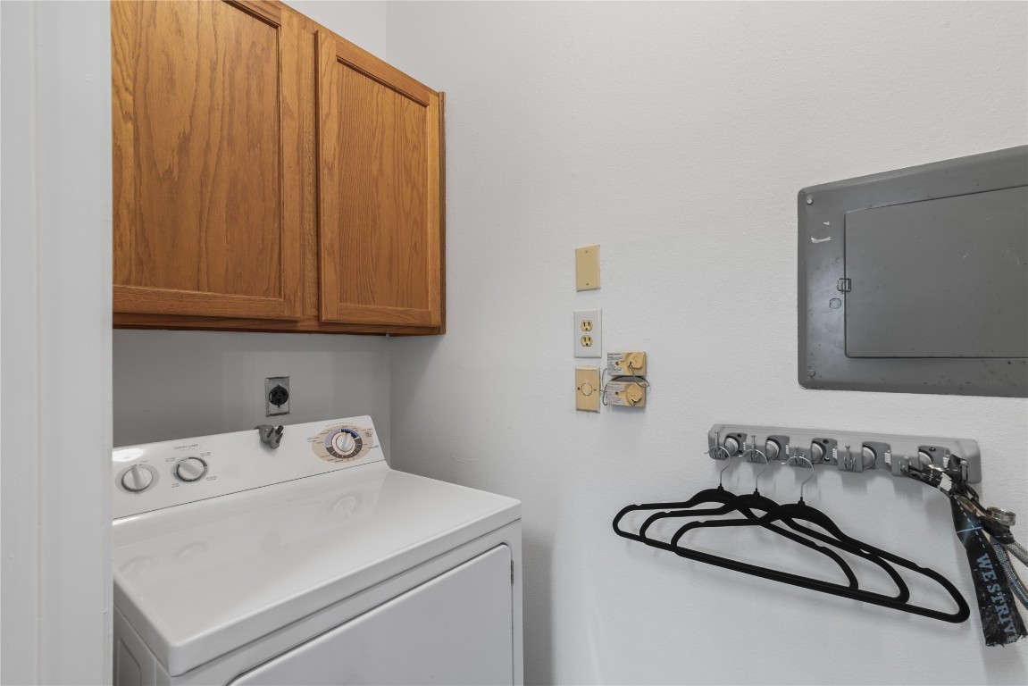 3500 Tangle Brush Drive, Unit 193 Spring, TX 77381 - Photo 10 of 26 Washing machine, overhead wooden cabinets for storage, and a wall-mounted hanger rack, ideal for organizing.