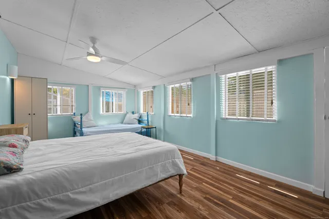 a bedroom with a large bed chandelier and a window