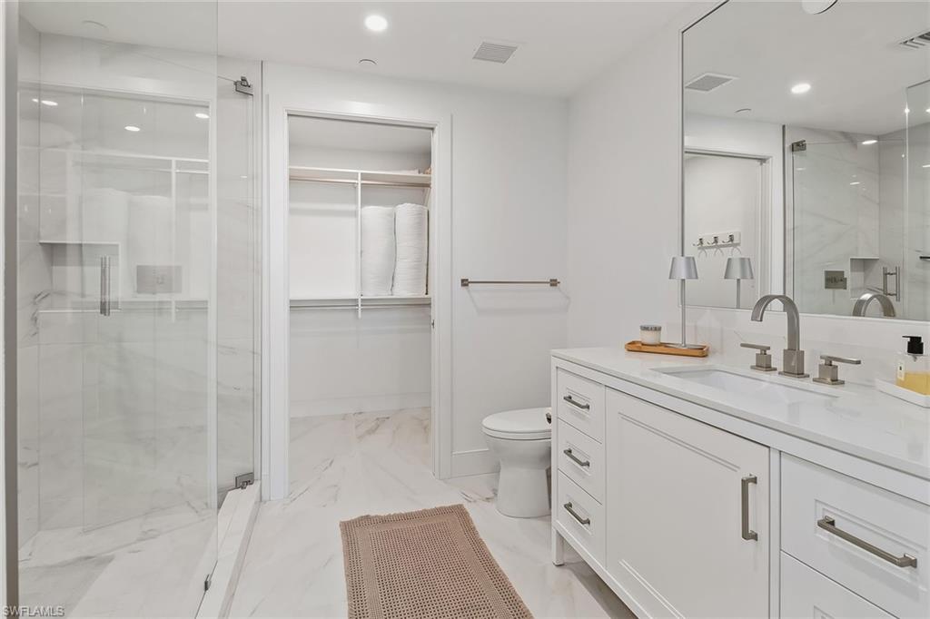 13935 Old Coast Road, Unit 2206 Naples, FL 34110 - Photo 17 of 50 Elegant en-suite bath highlighted by a glass walk-in shower, quartz finishes, and custom built-in closet