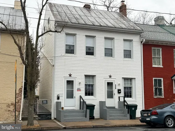 a front view of a residential houses with yard