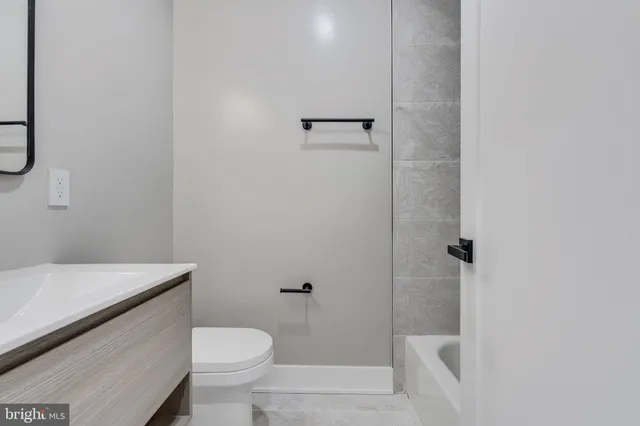 a white toilet sitting next to a bathroom sink