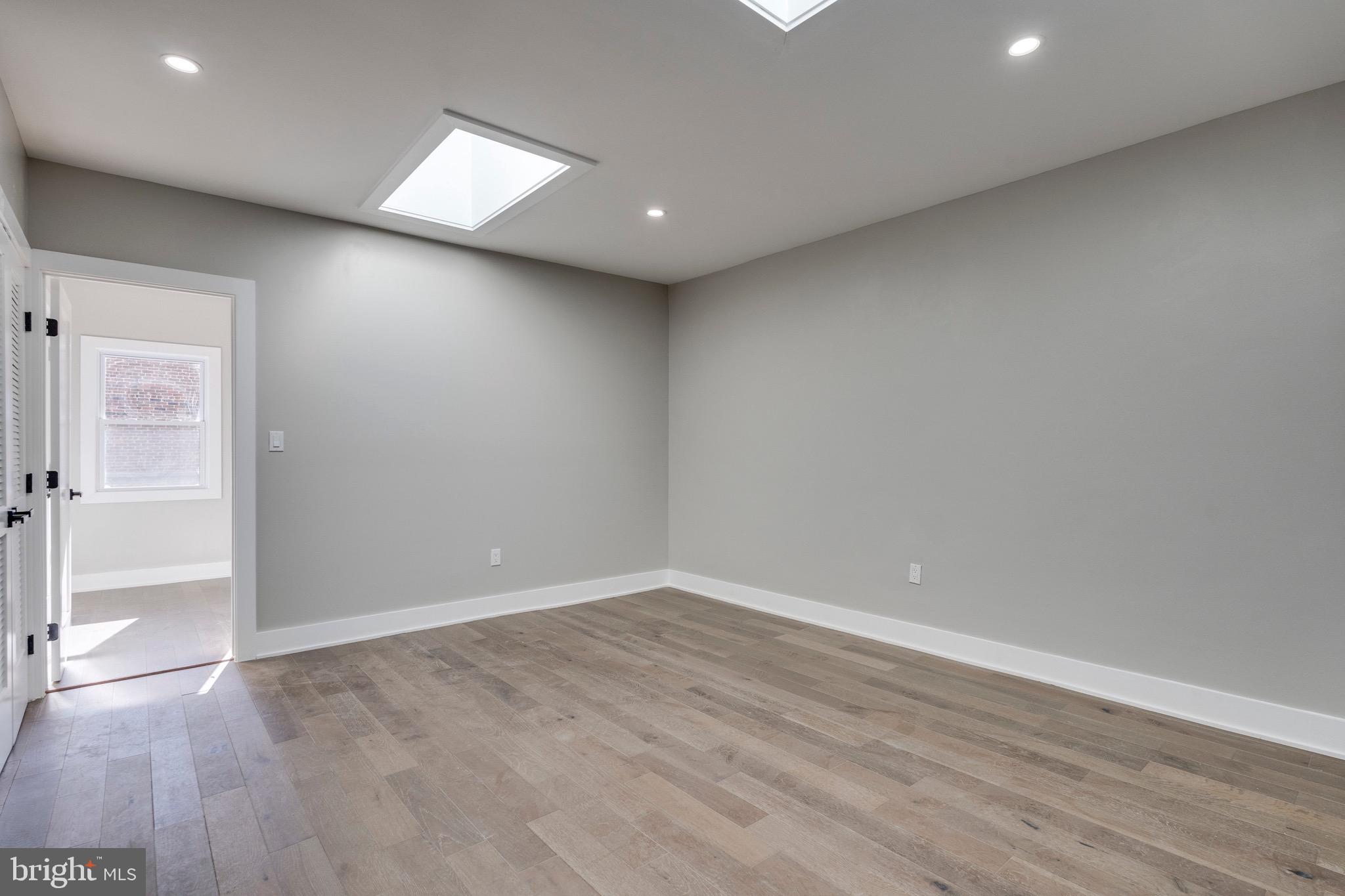 1703 West Virginia Avenue Northeast, Unit 2 Washington, DC 20002 - Photo 18 of 54 an empty room with wooden floor and windows