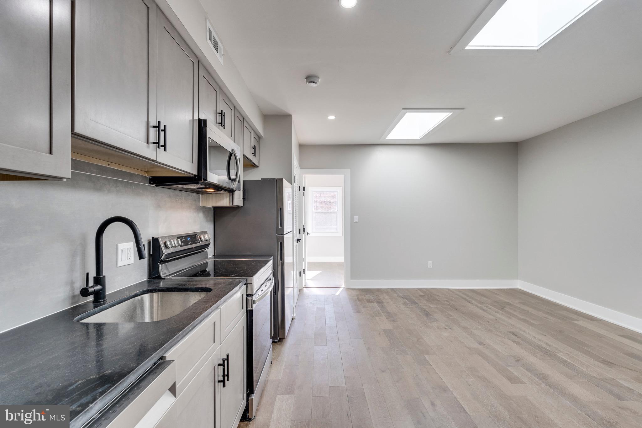 1703 West Virginia Avenue Northeast, Unit 2 Washington, DC 20002 - Photo 19 of 54 a kitchen with stainless steel appliances granite countertop a sink a stove and a refrigerator