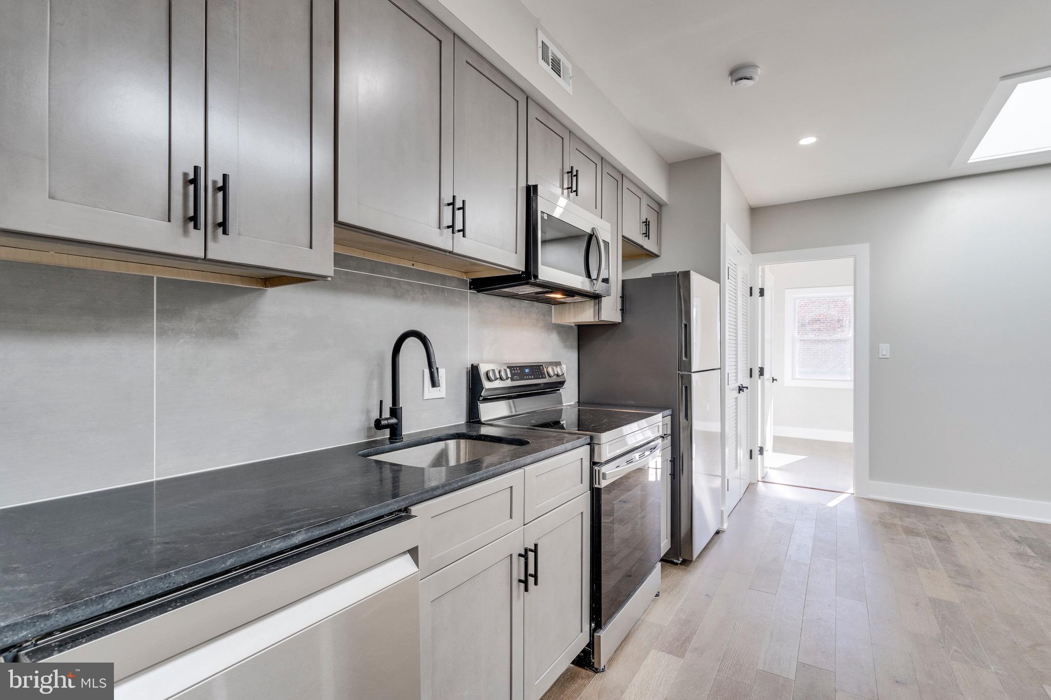 1703 West Virginia Avenue Northeast, Unit 2 Washington, DC 20002 - Photo 20 of 54 a kitchen with stainless steel appliances granite countertop a sink a stove and a refrigerator