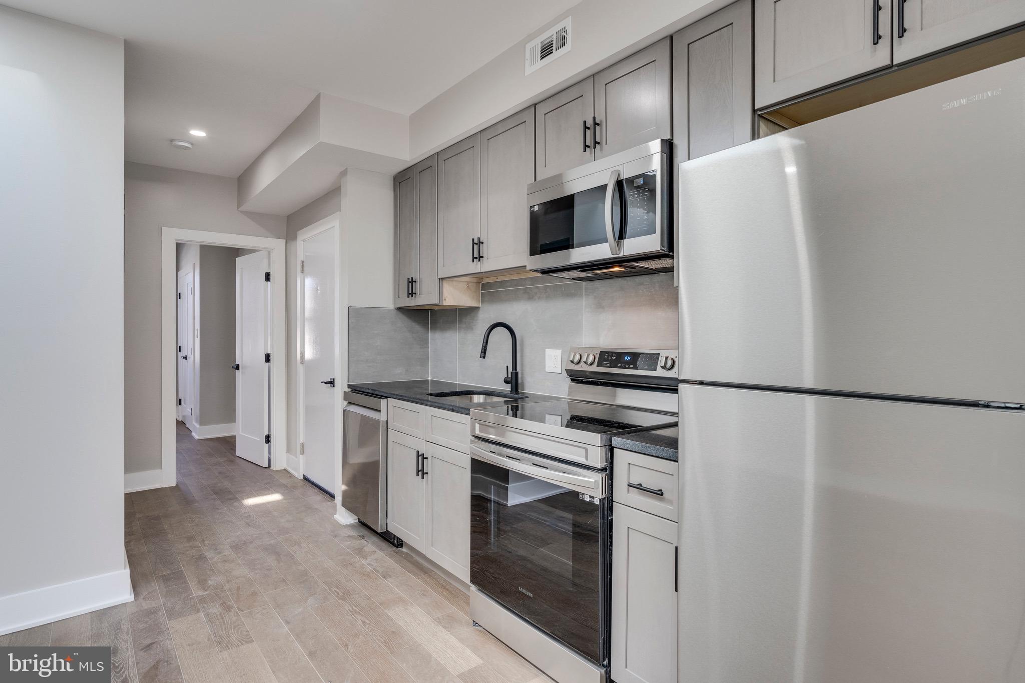 1703 West Virginia Avenue Northeast, Unit 2 Washington, DC 20002 - Photo 25 of 54 a kitchen with stainless steel appliances a refrigerator sink and stove