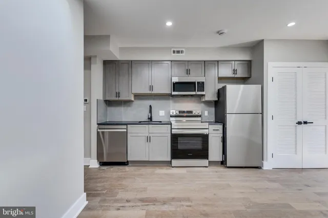 a kitchen with stainless steel appliances granite countertop a refrigerator sink and stove