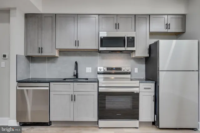 a kitchen with white cabinets and stainless steel appliances