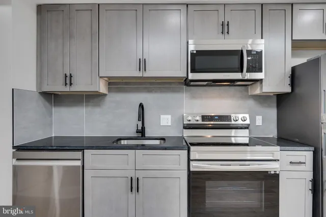 a kitchen with stainless steel appliances granite countertop a stove a microwave and oven