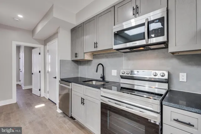 a kitchen with stainless steel appliances granite countertop a stove and a microwave