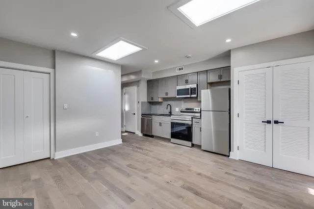 a kitchen with white cabinets and stainless steel appliances