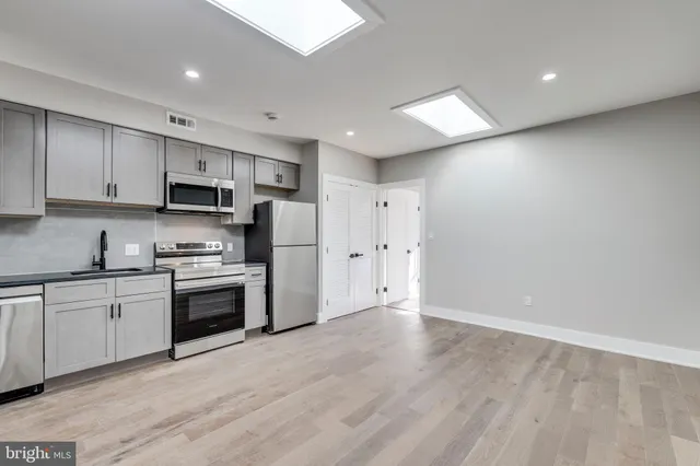 a kitchen with stainless steel appliances granite countertop a stove a sink and a refrigerator