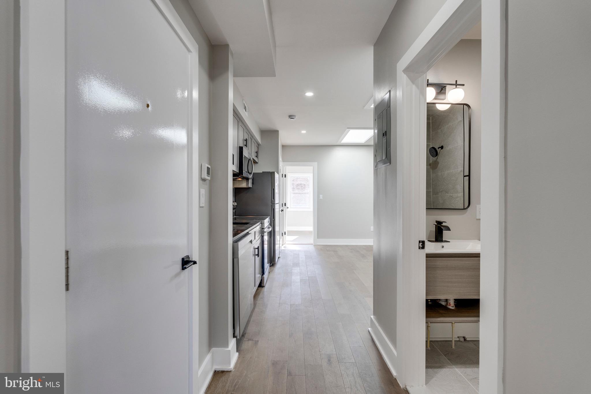 1703 West Virginia Avenue Northeast, Unit 2 Washington, DC 20002 - Photo 5 of 54 a view of a hallway with wooden floor and a bathroom