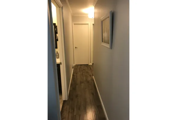 a view of a hallway with wooden floor