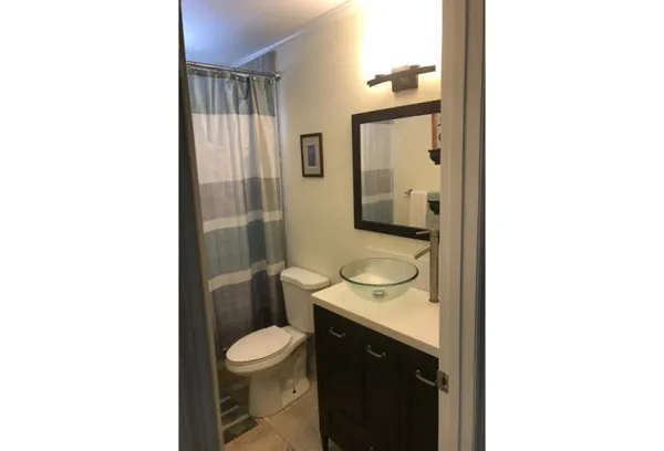 a bathroom with a granite countertop sink toilet a mirror and shower