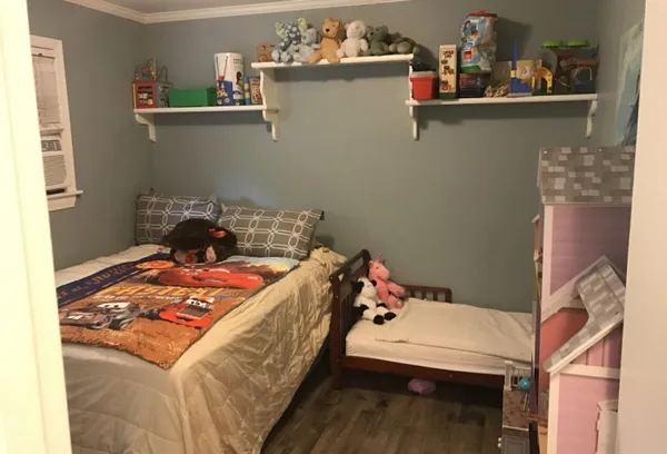 a bed sitting in a bedroom next to a window