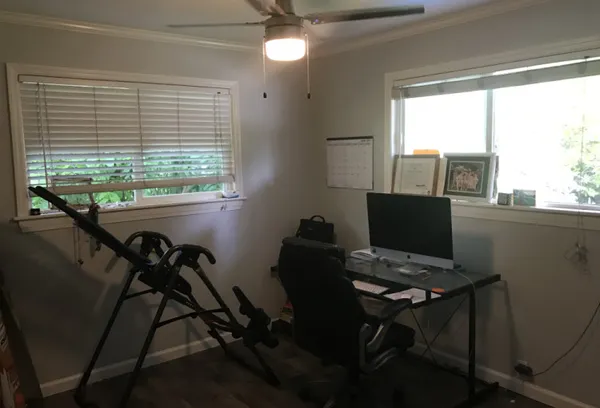 a view of a workspace with furniture and a window