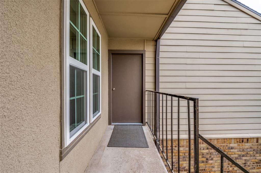 5300 Keller Springs Road, Unit 2042 Dallas, TX 75248 - Photo 2 of 28 Entryway featuring a solid brown door, siding, and multi-pane windows