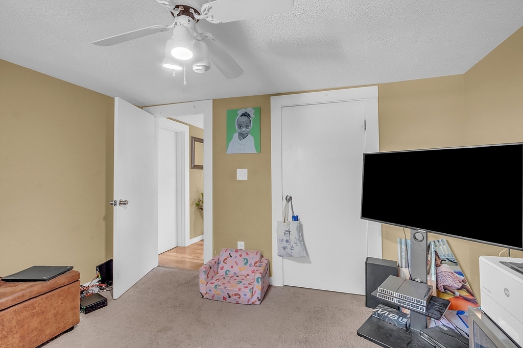 296 Howe Street Methuen, MA 01844 - Photo 8 of 12 a living room with furniture and a flat screen tv