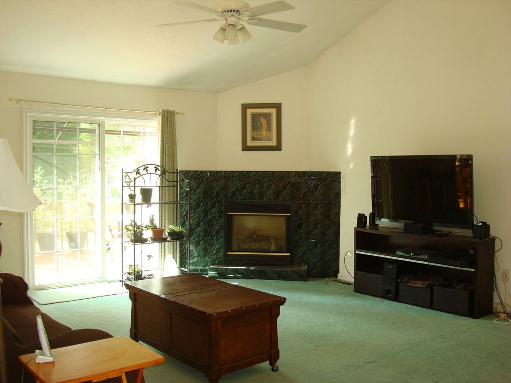 18 Rebecca Road Freetown, MA 02702 - Photo 3 of 30 a living room with furniture a flat screen tv and a fireplace