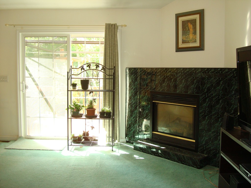 18 Rebecca Road Freetown, MA 02702 - Photo 6 of 30 a living room with a fireplace and a flat tv screen next to a window