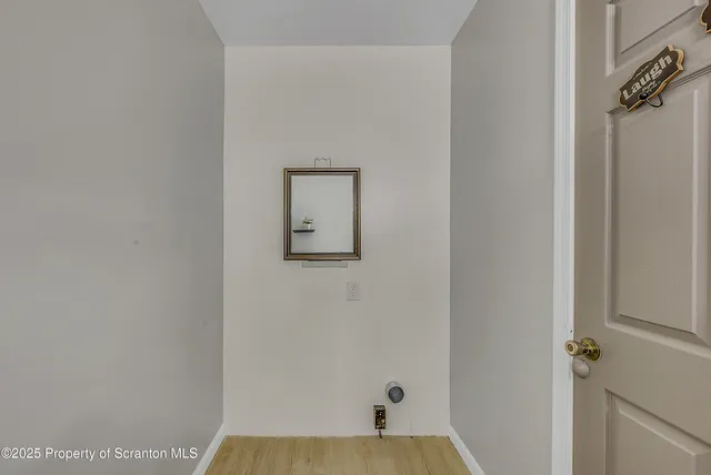 a view of a small space with wooden floor and a window