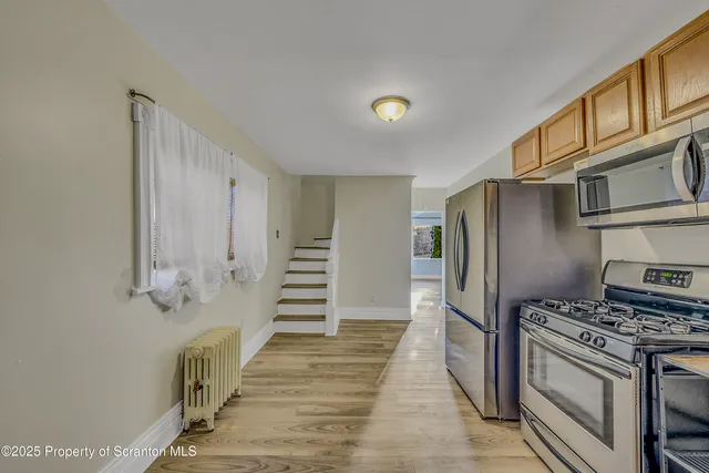a kitchen with stainless steel appliances granite countertop a refrigerator and a stove