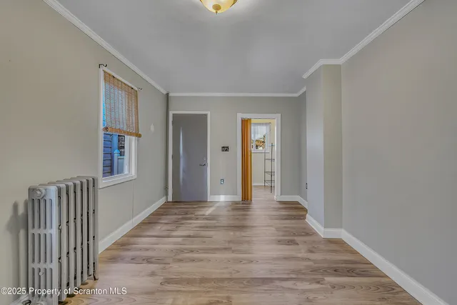 a view of a hallway with wooden floor and entryway