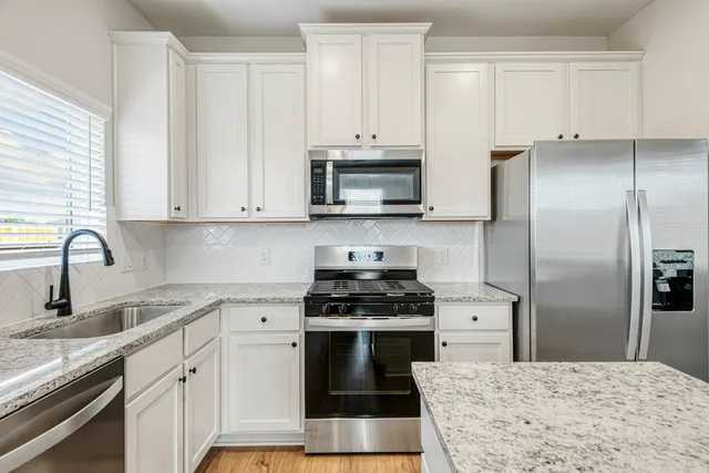 a kitchen with cabinets stainless steel appliances and a sink