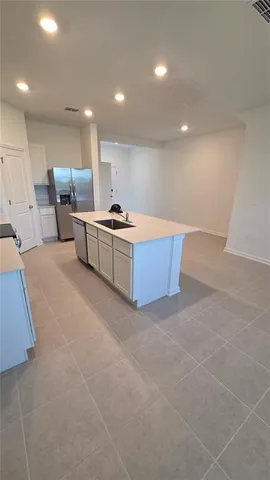 a living room with stainless steel appliances furniture a rug and a projector