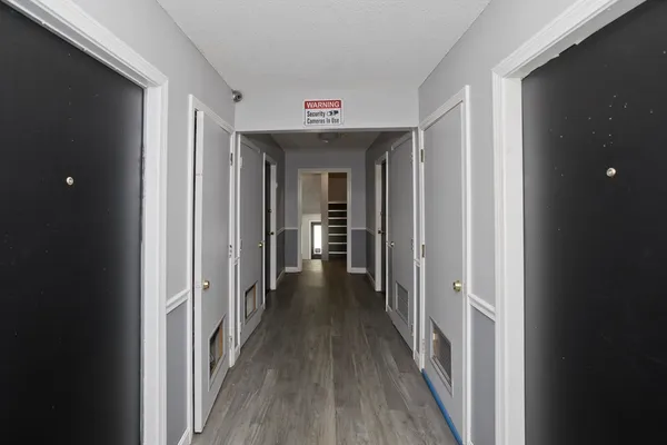 a view of a hallway with wooden floor and a living room