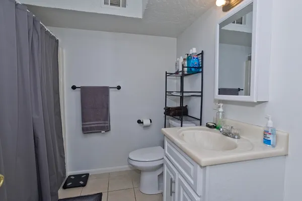 a bathroom with a sink vanity mirror and toilet