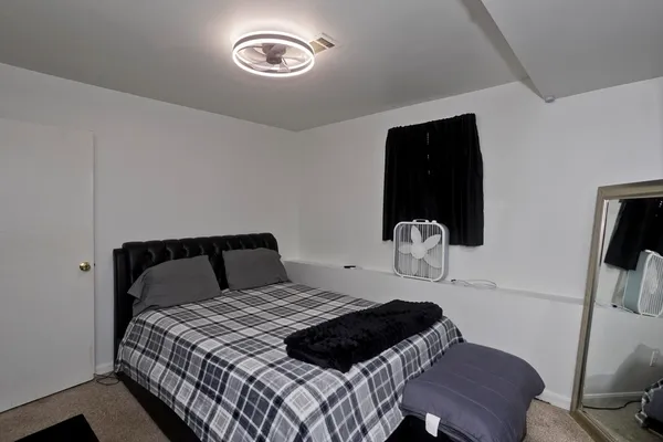 a bedroom with a bed and a flat tv screen on the dresser