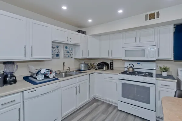 a kitchen with cabinets stainless steel appliances and sink