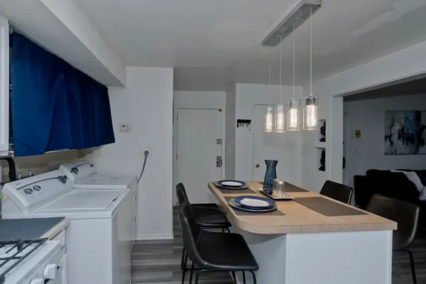 a view of a kitchen area with furniture and wooden floor