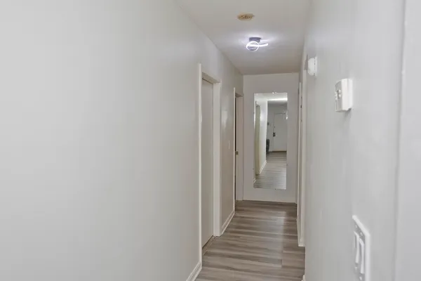 a view of a hallway with wooden floor and staircase