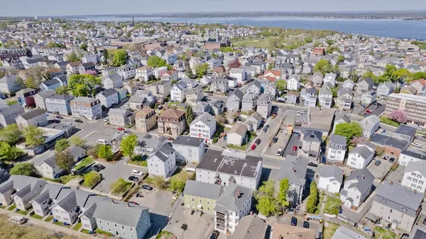 an aerial view of multiple house with large trees