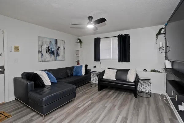 a living room with furniture and a wooden floor