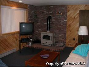 1230 Brookfield Road Lake Ariel, PA 18436 - Photo 3 of 7 a living room with furniture a flat screen tv and a fireplace