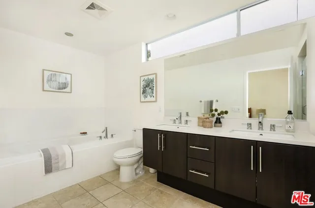 a bathroom with a double vanity sink mirror and shower