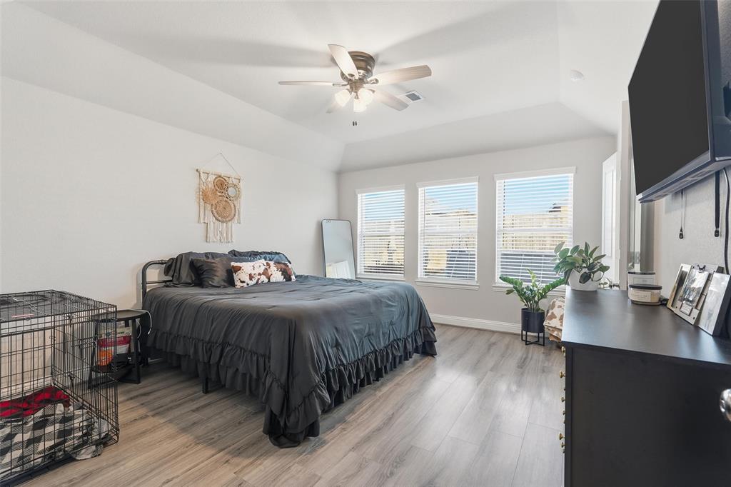 2148 Erika Lane Forney, TX 75126 - Photo 14 of 21 a bedroom with a bed a large window and wooden floor