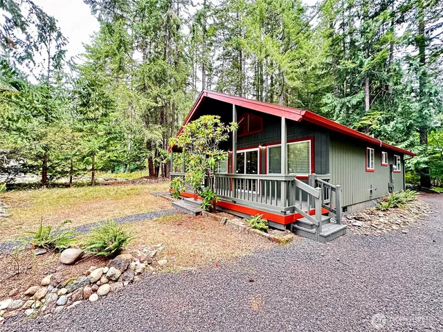 a view of backyard with a deck and wooden fence