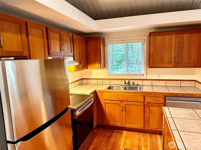 a view of a kitchen with a sink and wooden floor